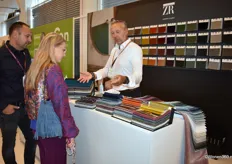 Randolf van Kuik (rechts) druk in gesprek met bezoekers op zijn stand. Namens de textielfabrikant toonde hij de nieuwe collectie Zimmer+Rohde.